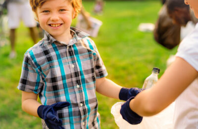 Boy picking up garbage in the park