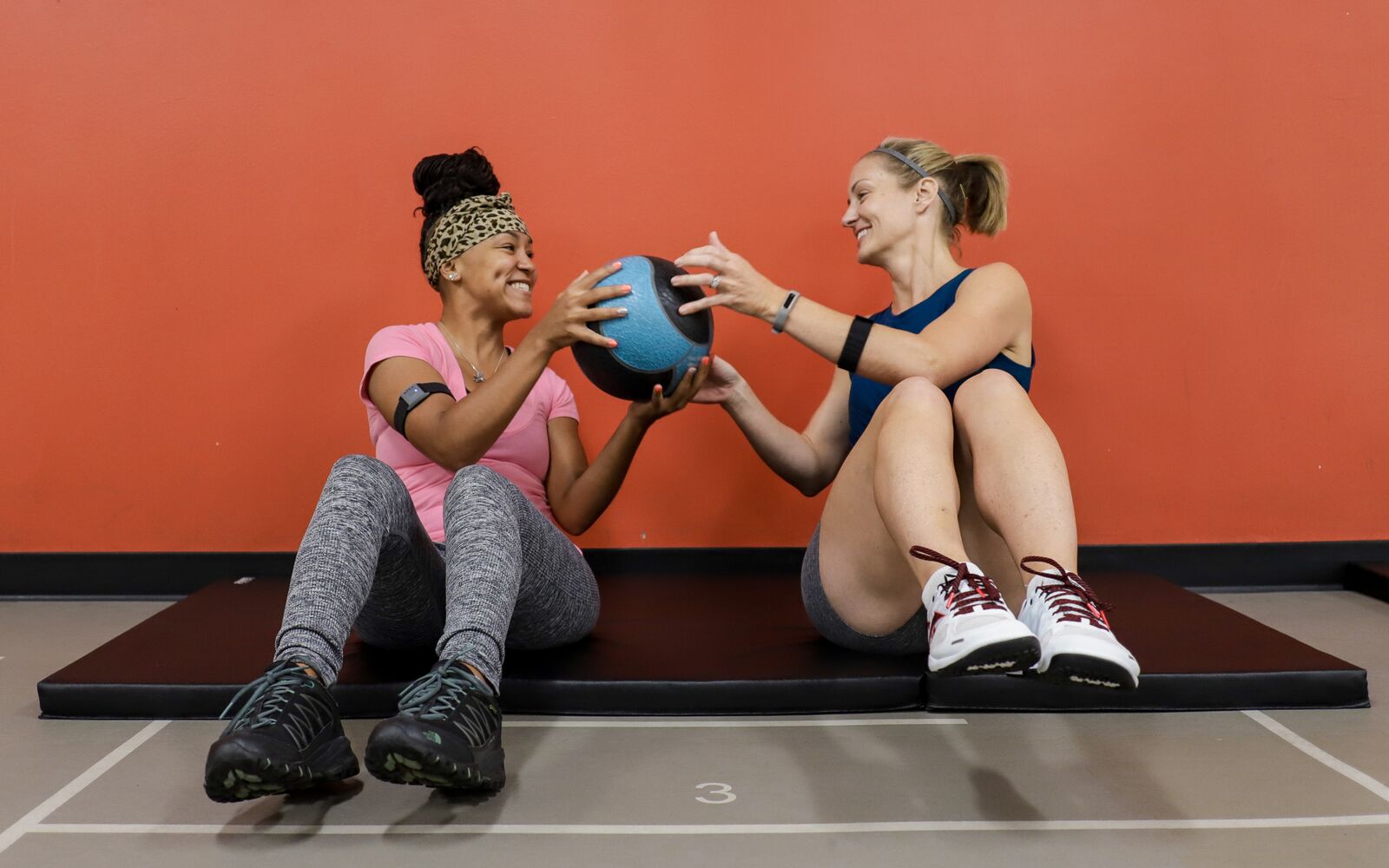 Two Women in Group Bootcamp Class holding Weight Medicine Ball