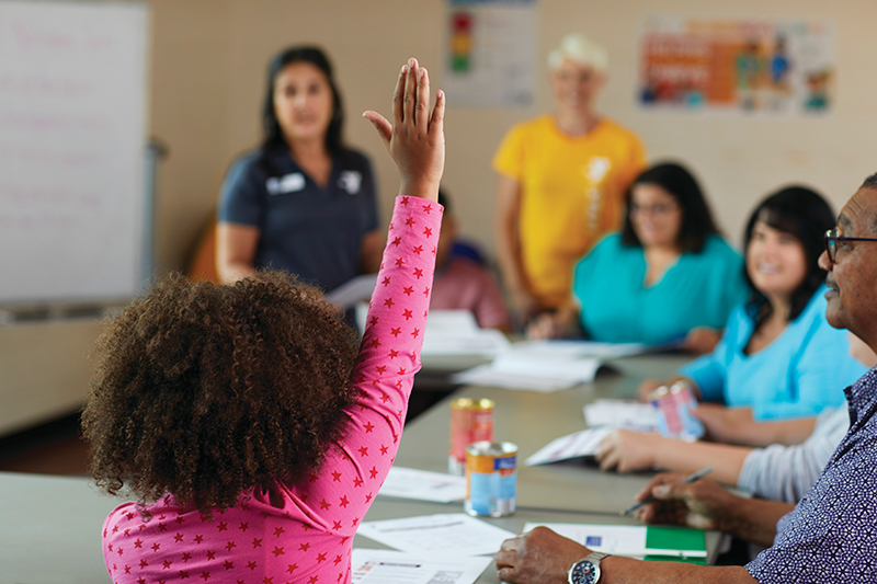 Child Raising Hand in YMCA Classroom