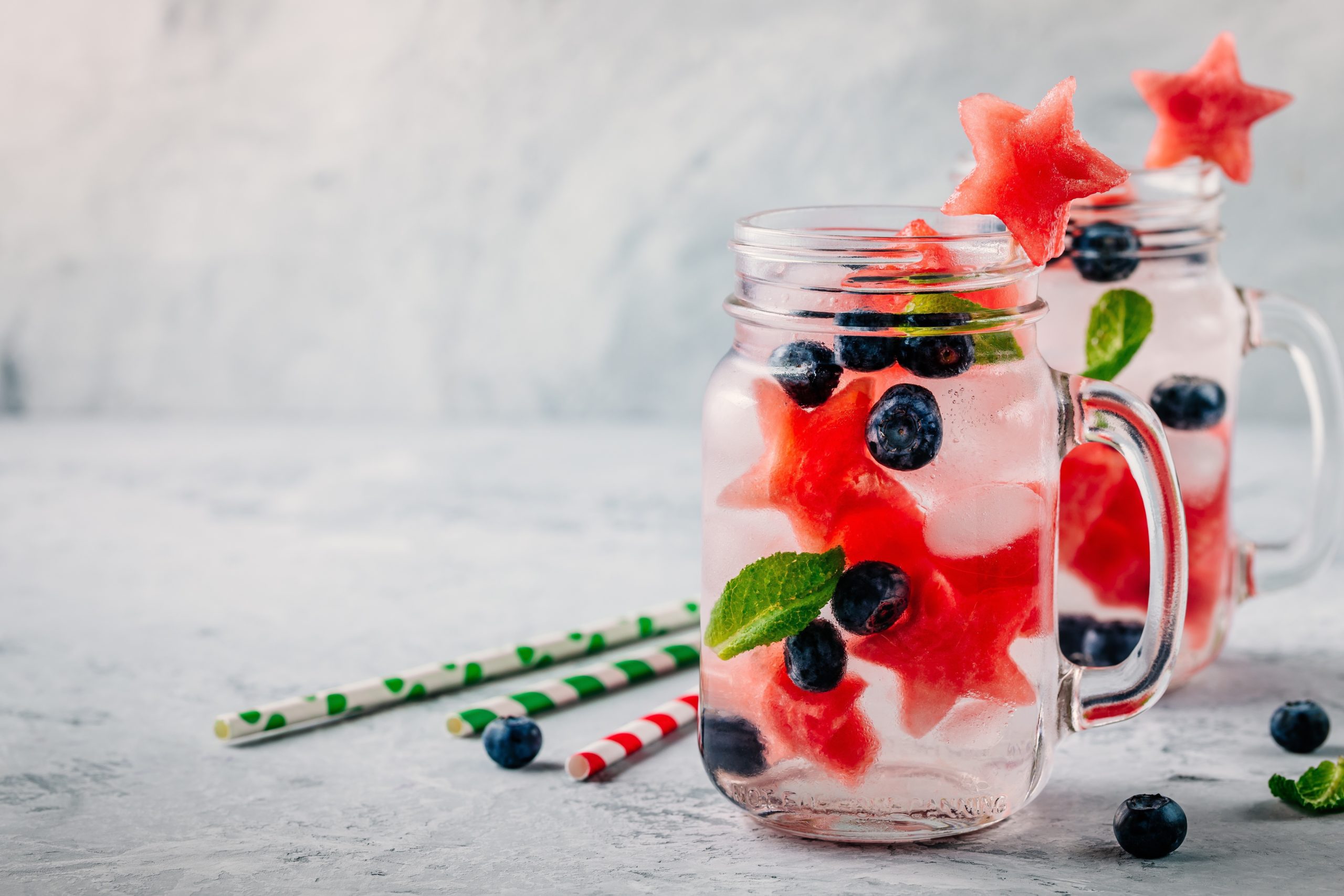 Watermelon blueberry water in mason jar cup on stone surface