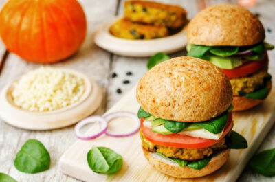 Black bean burgers on wooden cutting board with vegetable condiements