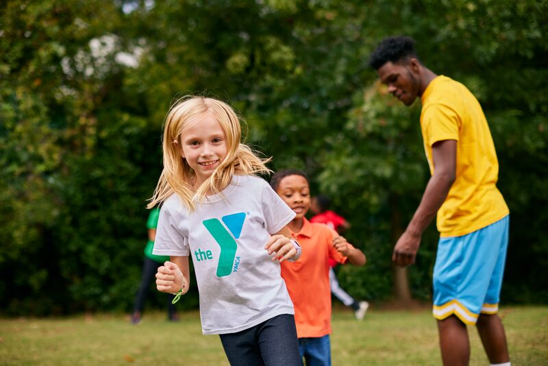 Kid running in line with a YMCA t-shirt on outside