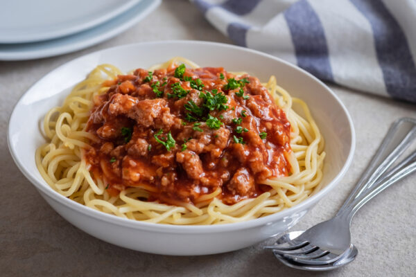 Spaghetti with Bolognese Meat Sauce in a White Pasta Dish with Forks