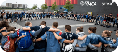 Image of people in a circle embracing around the World YMCA building in Ukraine