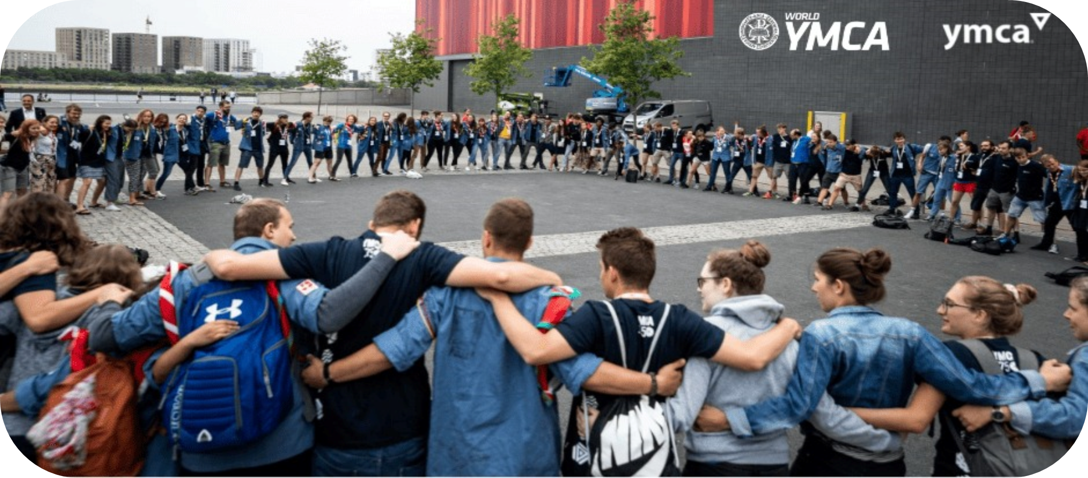 Image of people in a circle embracing around the World YMCA building in Ukraine