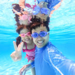 asian cute daughter and father play and selfie happily in the swimming pool