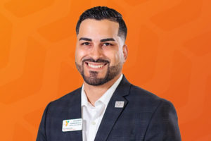 Headshot of Eduardo Emmanueli in front of orange chevron background