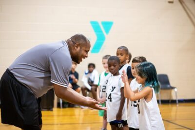 Referee giving high fives to basketball players in the gym