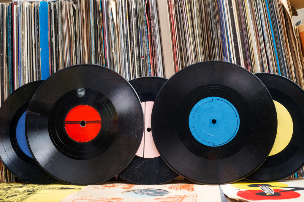 Vinyl record with copy space in front of a collection of albums dummy titles, vintage process