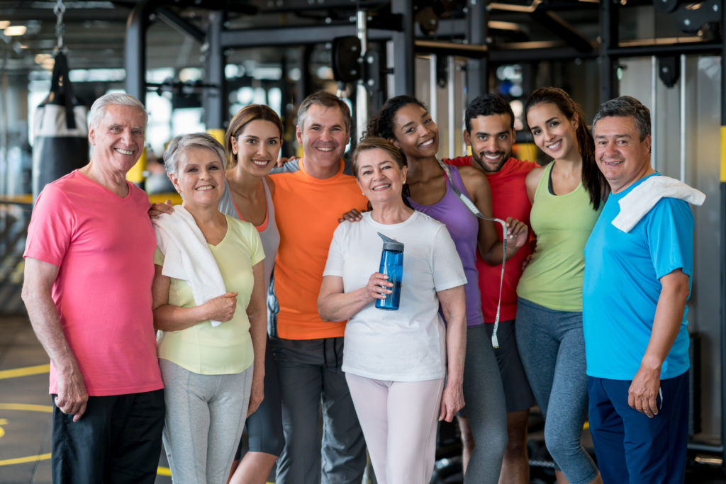 Happy group of Latin American people at the gym looking at the camera smiling - healthy lifestyle concepts