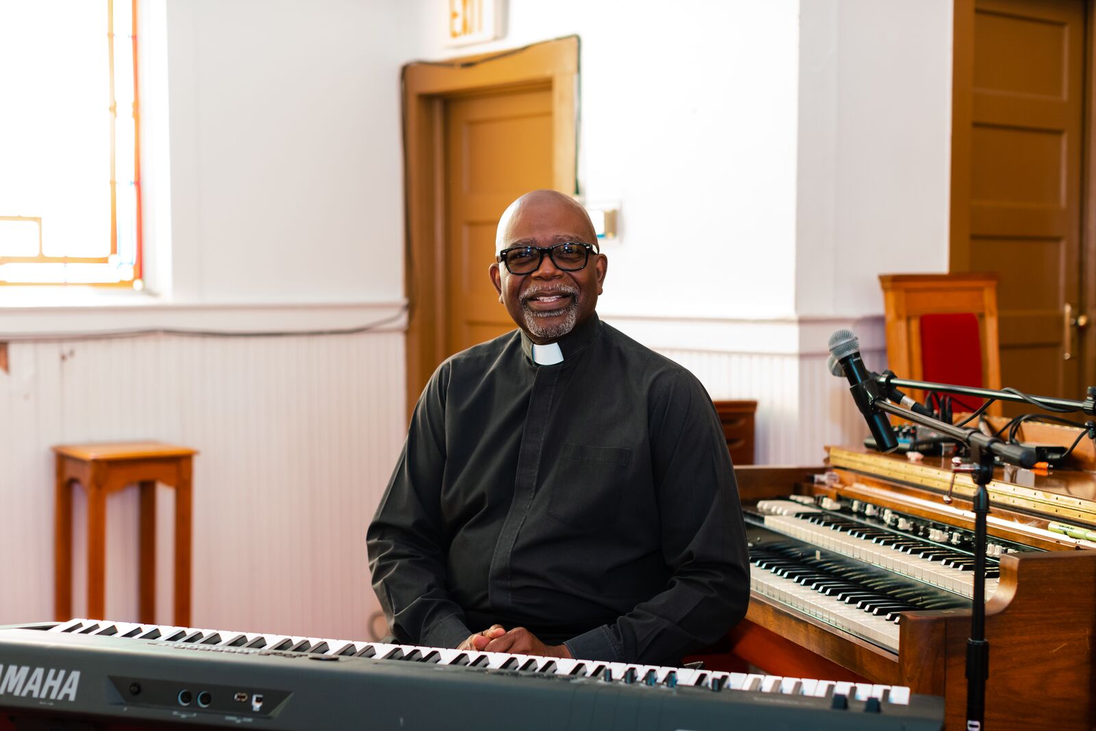 Image of Reverend Archie Adams sitting at the keyboard in his home church