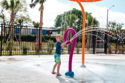 Young boy playing at splash pad at Leonard & Marjorie Williams Family YMCA