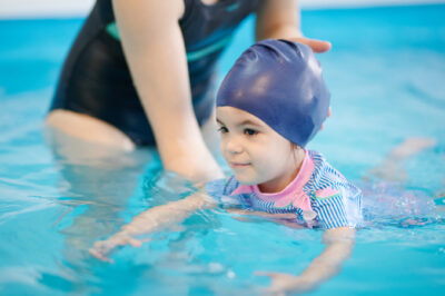 YMCA of Central Florida - Learning to swim from childhood theme. Kid swimming in blue pool water