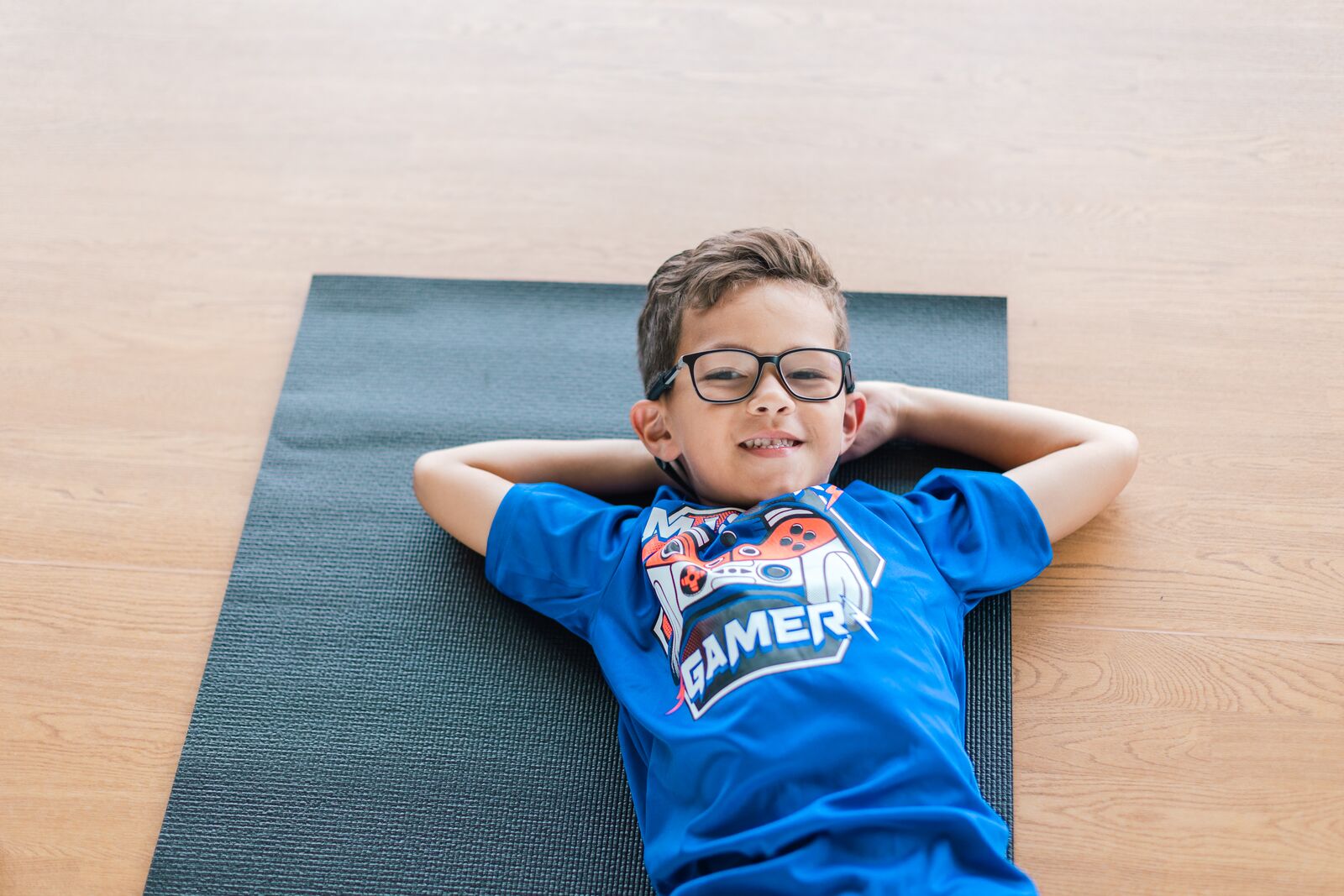 Boy sitting on a yoga mat at Leonard & Marjorie Williams Family YMCA in the Packing District