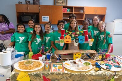 a group of kids at the YMCA summer camp enjoying a cooking activity