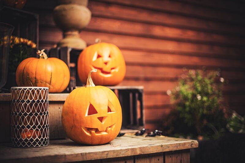 Jack-o-lanterns set up on front steps with other fall decorations