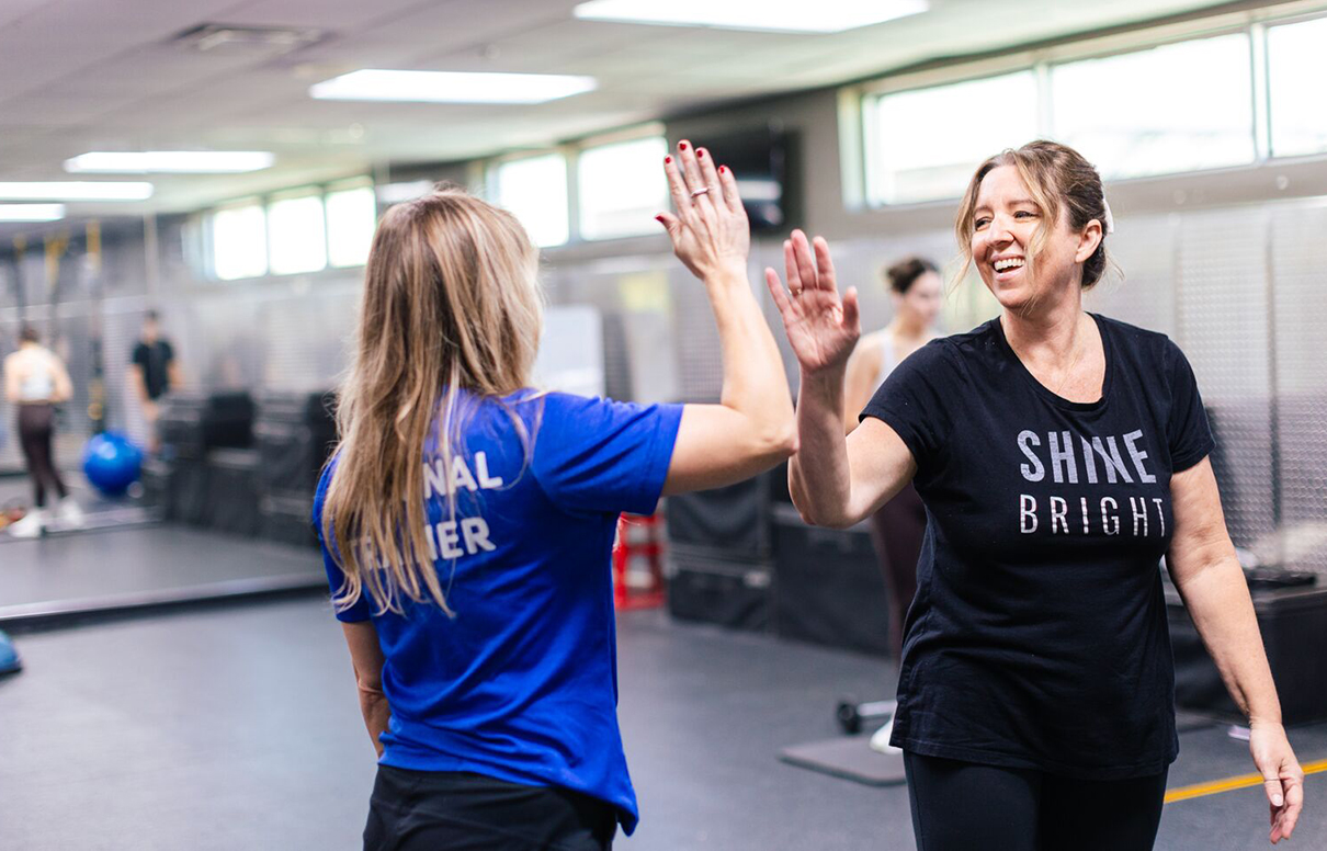 Personal Trainer Morgan Gelinas high-fiving her client at the Downtown Orlando YMCA