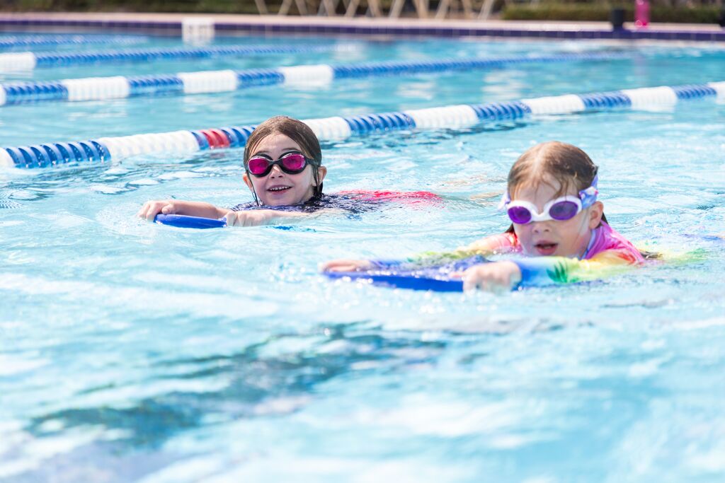 Two kids using kick boards during their swim lesson
