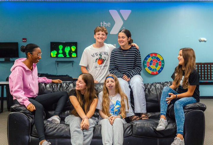 A group of teenagers on a couch at the YMCA teens lounge at the Dr. P Phillips YMCA in Orlando