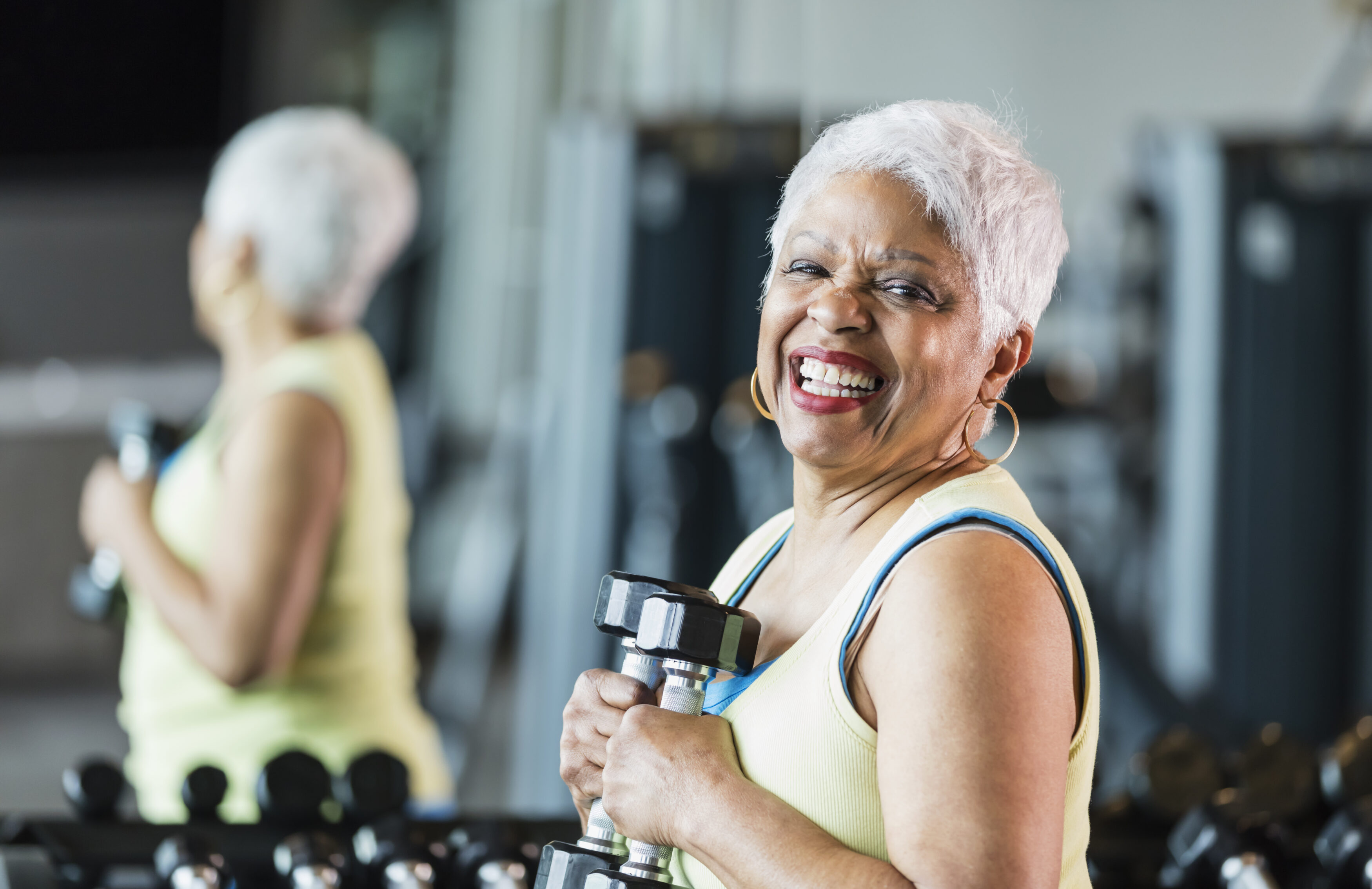 A woman lifting a weight at the Parrish Health & Fitness Center operated by the YMCA of Central Florida, demonstrating strength training.