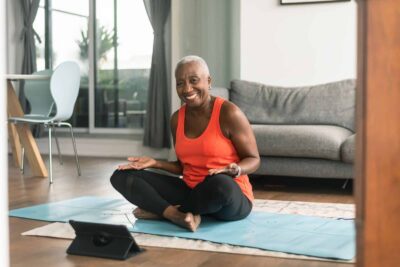 Woman doing yoga at home following a YMCA Virtual Fitness session
