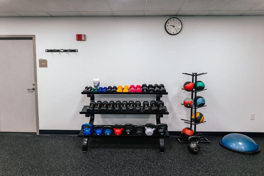 Free weights and benches in the fitness area at Parrish Health & Fitness Center, operated by the YMCA of Central Florida.