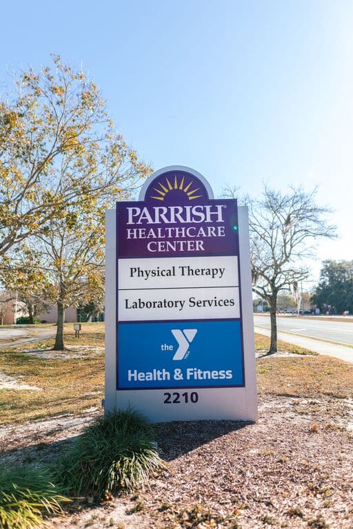 Exterior sign for Parrish Health & Fitness Center, operated by the YMCA of Central Florida, outside the building.