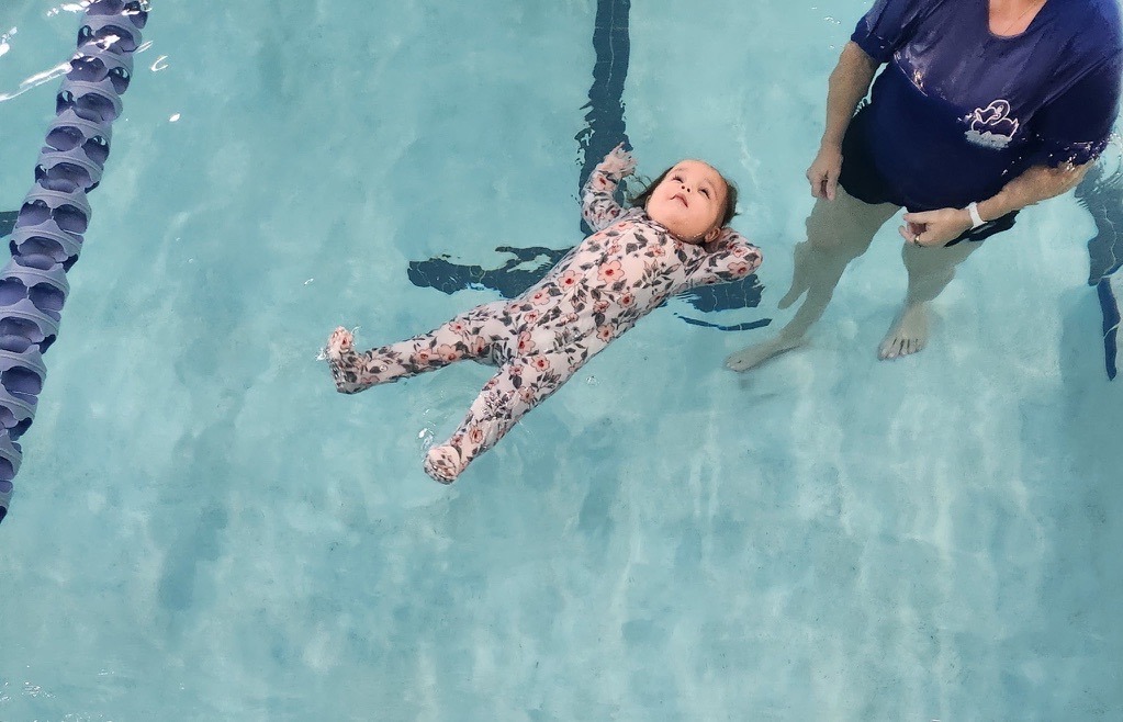 Baby floating in pajamas during their Safe Start ISR Swim Lessons at the Oviedo YMCA