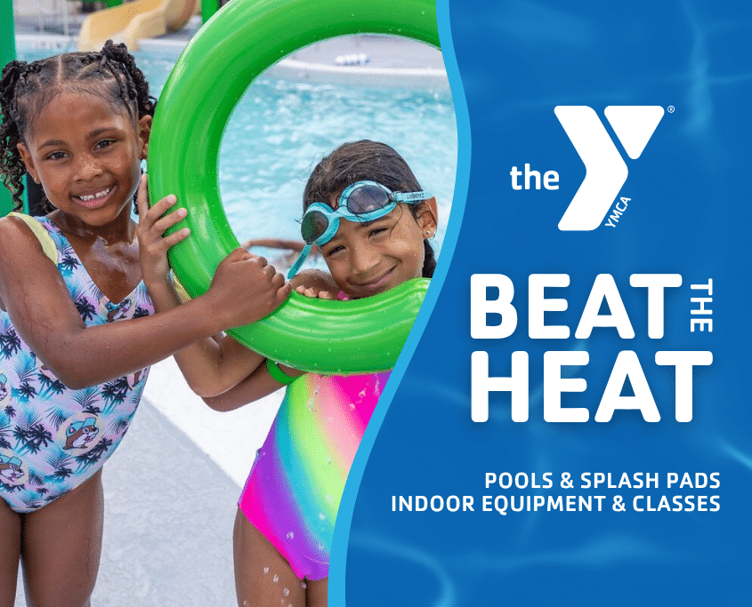 Two girls playing and laughing at a YMCA splash pad during summer Beat the Heat campaign activity.