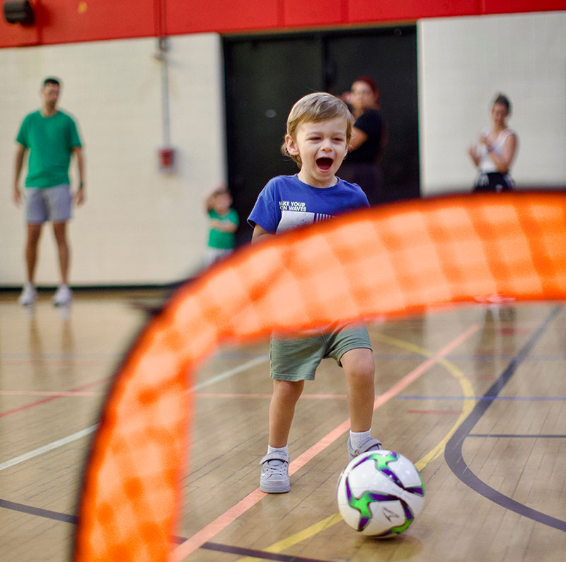 Little boy getting ready to kick a soccer ball into a goal