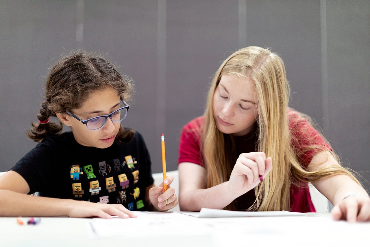 A YMCA counselor helping a girl with her homework in the After School Program in Osceola County, FL