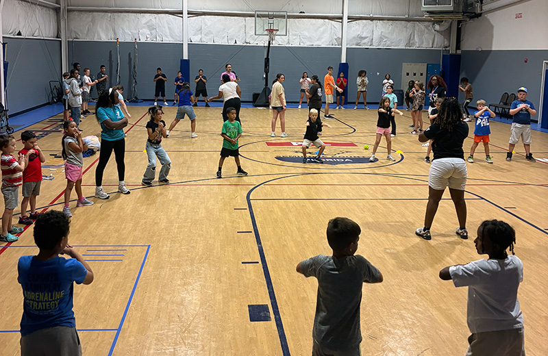 Y on the Fly team running a fitness class at a community gym
